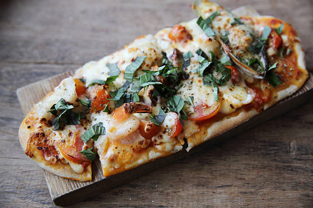 istock pizza with seafood and tomatoes on a wooden table 547213984