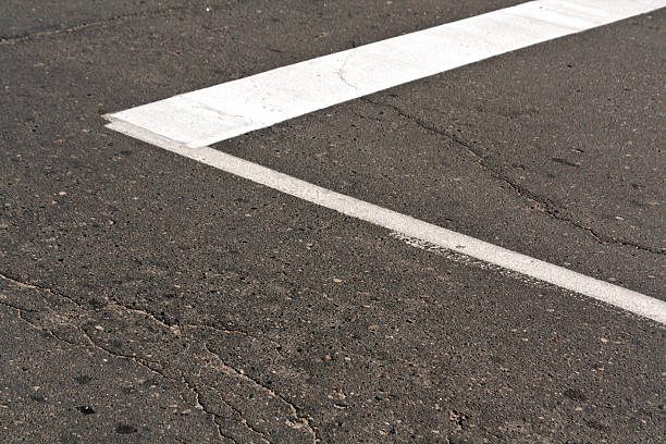 istock White paint mark on the old asphalt road. 547214410
