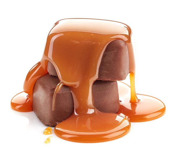 karamellsauce gießt auf schokoladenbonbons - karamelisiert stock-fotos und bilder