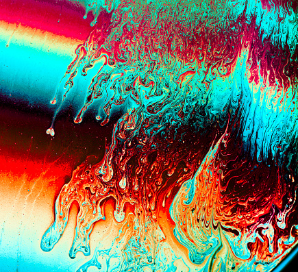 Macro shooting of soap film with illuminated. Multi Colored bright abstract background. Colorful waves, loops, strips and stains on surface