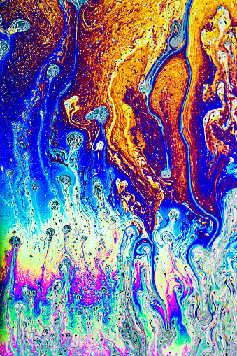 Macro shooting of soap film with illuminated. Multi Colored bright abstract background. Colorful waves, loops, strips and stains on surface