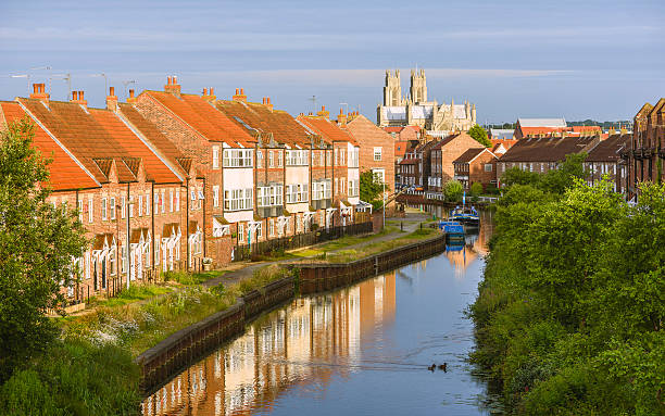 the minster, town houses, and the beck, beverley, yorkshire, uk. - canal narrow boat nautical vessel england fotografías e imágenes de stock