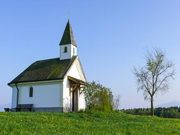 istock Small stone chapel in a Springtime meadow field IV 547220312