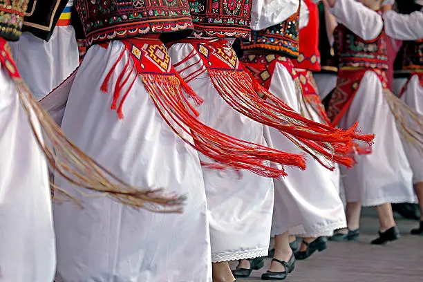 Romanian dancers in traditional costume, perform a folk dance.