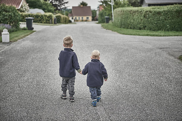 istock Two boys running in small suburban street 547226256