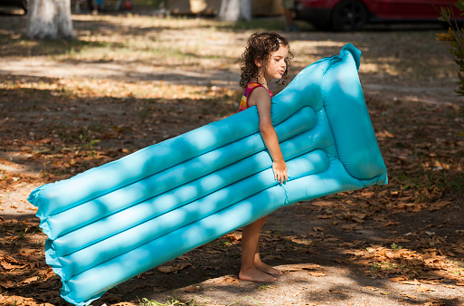 little girl having fun oudoor with air bed