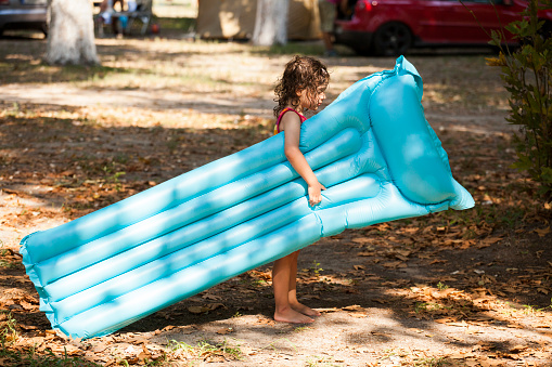 little girl having fun oudoor with air bed