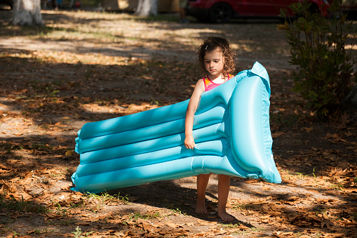 little girl having fun oudoor with air bed