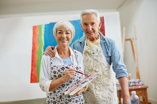 Shot of a senior couple painting at home