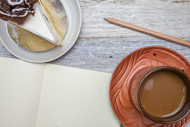 Brownie cheese cake,pencil and coffee on wooden background