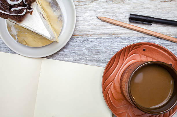 Brownie cheese cake,pencil,pen and coffee on wooden background