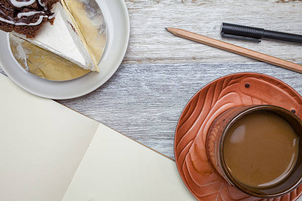 Brownie cheese cake,pencil,pen and coffee on wooden background