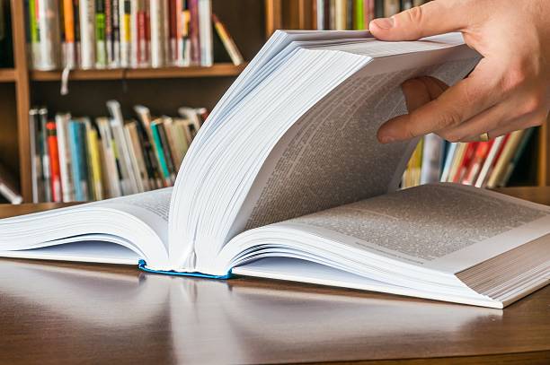 istock The hand opening and browsing the book pages 547239028