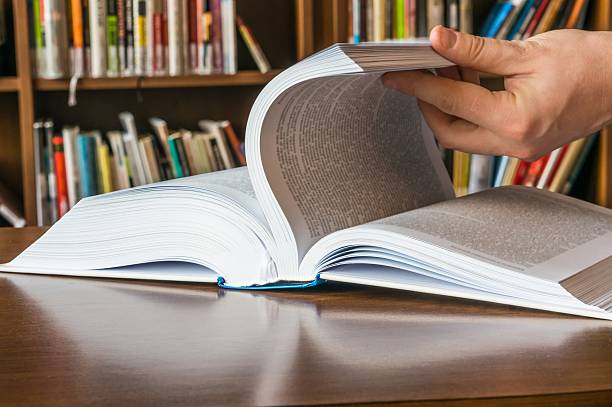 istock The hand opening and browsing the book pages 547239040