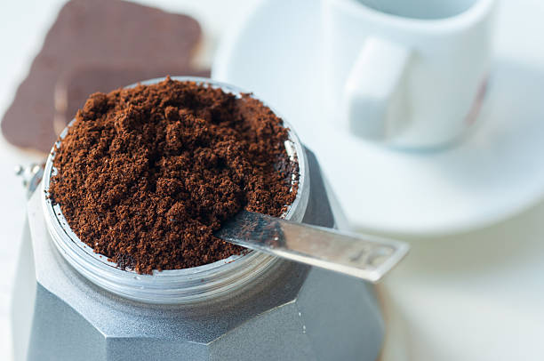 Italian coffee with ground coffee and a cup Cooking Italian coffee on the table are a coffee maker with coffee, biscuits and a cup of white chocolate dump radiator stock pictures, royalty-free photos & images