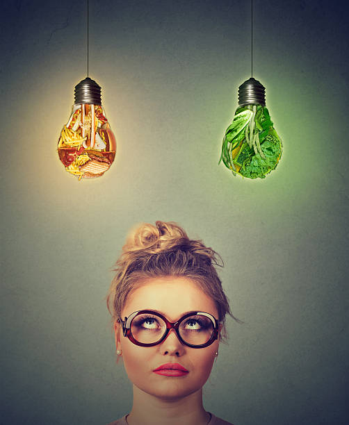 istock Woman looking up at junk food vegetable light bulb 547241138