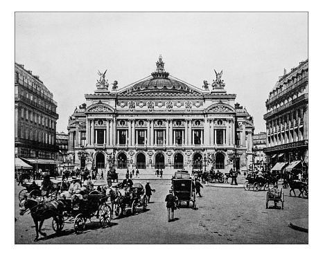 Antique photograph of the facade of the Palais Garnier (Paris, France) in a 19th century picture. The opera house overlooking Place de l'Opéra is also called the Opéra Garnier and it is built in Second Empire and Beaux-Arts style.