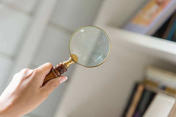 Hand holding magnifying glass stock photo