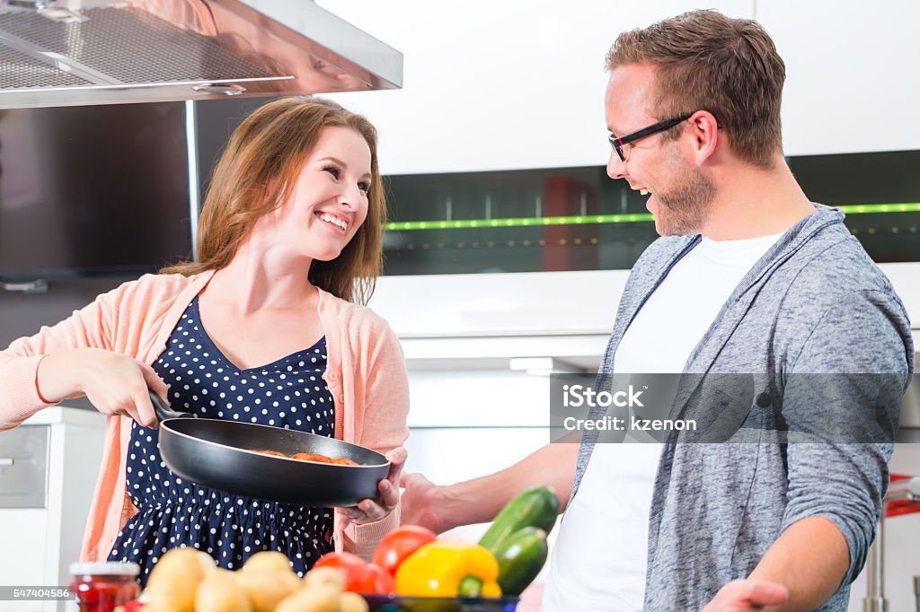 Couple cooking pasta in domestic kitchen Woman and man cooking spaghetti in domestic kitchen Adult Stock Photo