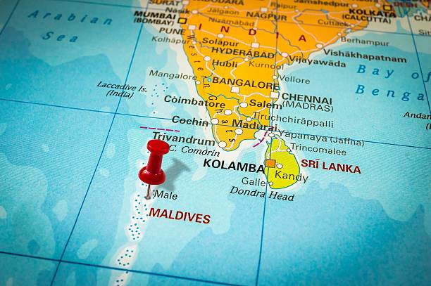 Red thumbtack in a map, pushpin pointing at Maldives stock photo