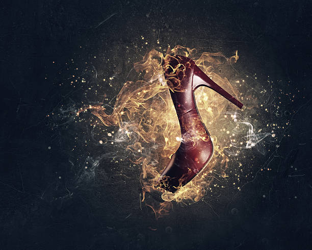 Red heeled shoe in fire flames on dark background