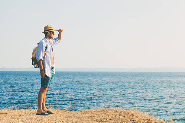 istock Tourist with backpack watching the sunset over the sea 547407524