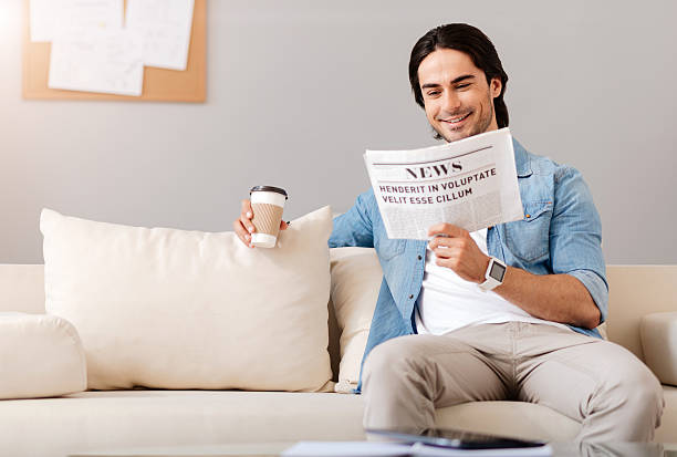 istock Pleasant delighted man reading newspaper 547411690