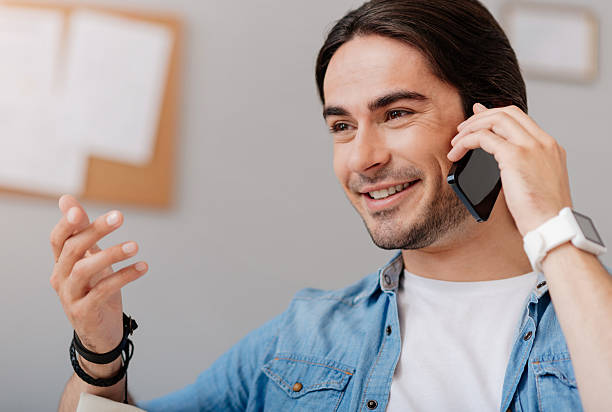 istock Joyful handsome man talking on cell phone 547412742