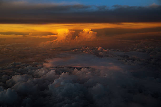 Thunderheads glow in the distance as the sun sets on a summer evenning above Iowa