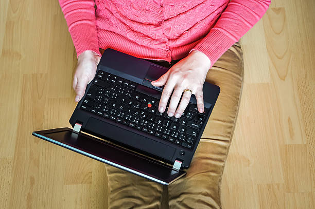 istock Young student using laptop and sitting on the wooden floor 547413628