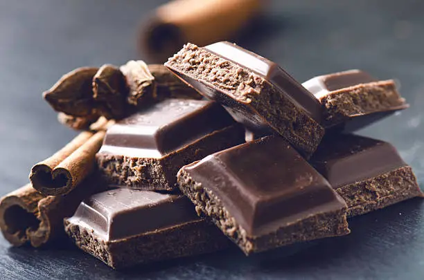 Photo of Two chocolate buildings on a dark background. energy and sugar.