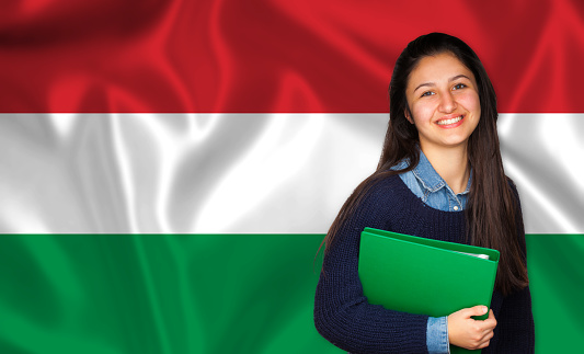 Teen student smiling over Hungarian flag. Concept of lessons and learning of foreign languages.