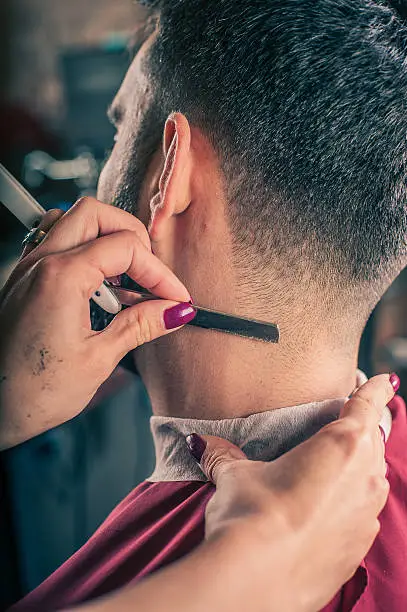 Photo of Female barber shaving a client