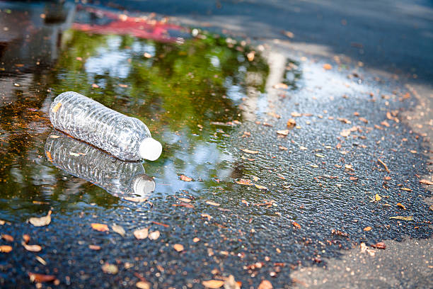 istock Pollution.  Empty plastic water bottle discarded on city street. 547416500
