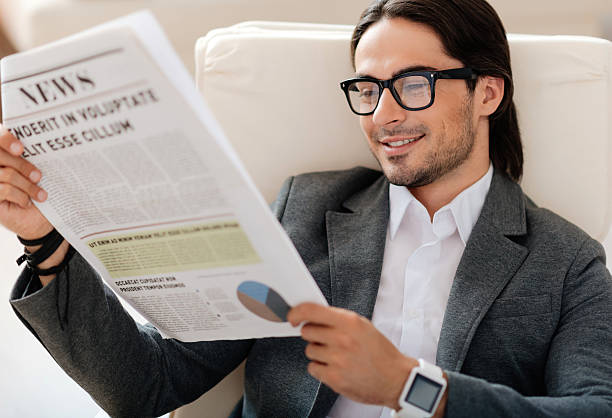 istock Pleasant smiling man reading newspaper 547417908