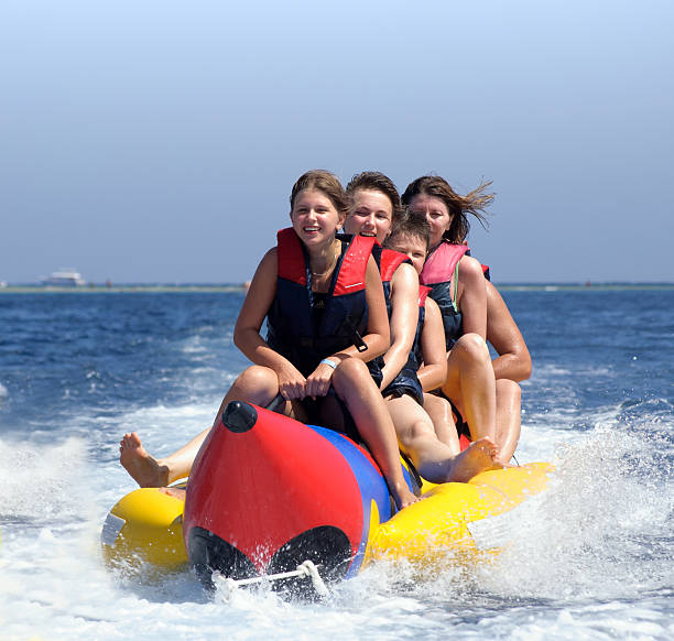 istock happy people having fun on banana boat 547419320