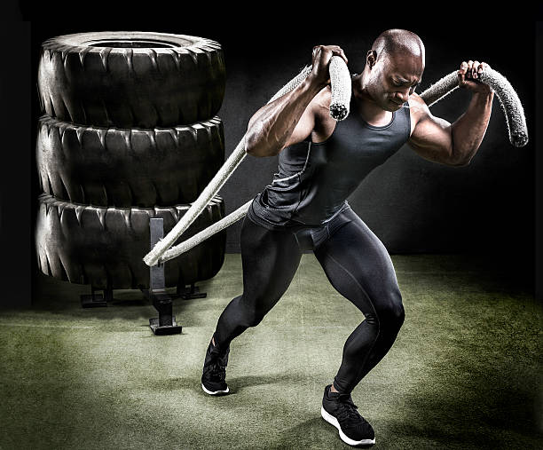 Muscular athlete pulling sled of tires. stock photo