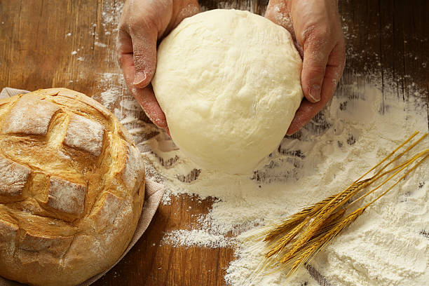 istock Chef hands with dough and homemade bread and flour 547419578