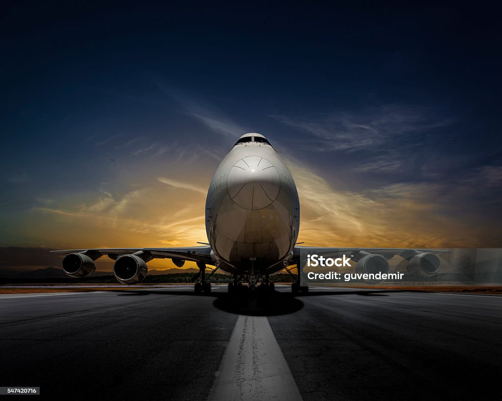 Passenger plane on runway at sunset Airplane Stock Photo