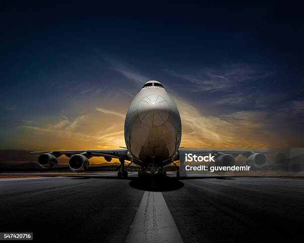 Passenger Plane On Runway At Sunset Stock Photo - Download Image Now - Airplane, Front View, Commercial Airplane
