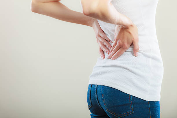 istock Backache. Young woman suffering from back pain 547423092