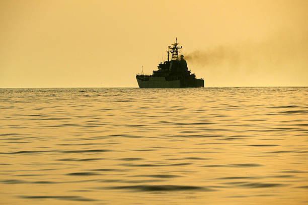istock silhouette of a warship at sunset 547423102
