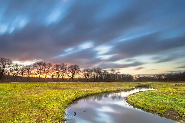 Sunset Creek with Blurred Clouds by Long Exposure as metaphore for Spiritual path and Personal Exploration.