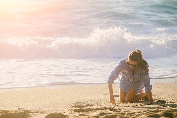 istock Young woman writing on sand 547424682