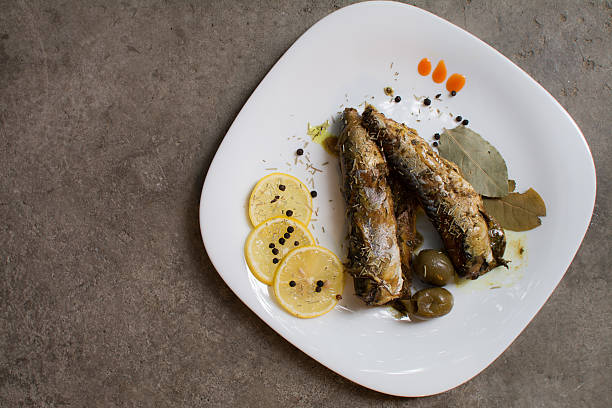 Fried Mackerel in a plate served with spices and lemon
