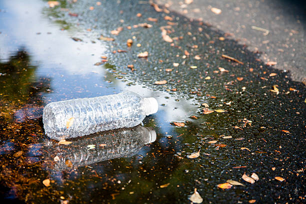 istock Pollution.  Empty plastic water bottle discarded on city street. 547427188