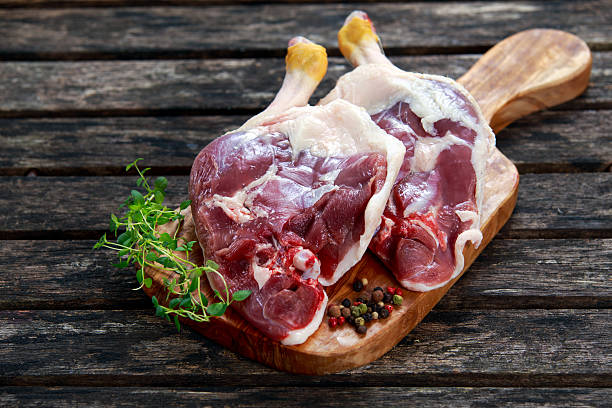 istock Free range Duck legs with herbs. on old wooden table. 547427552