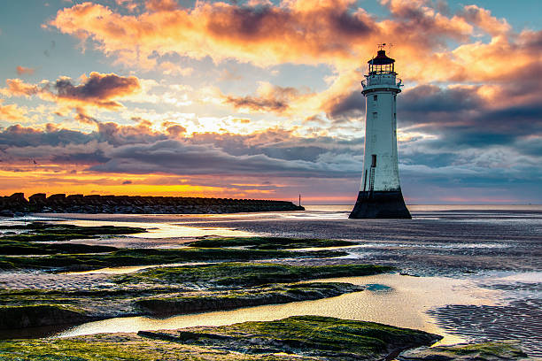 faro di perch rock e spiaggia al tramonto - perch rock lighthouse foto e immagini stock