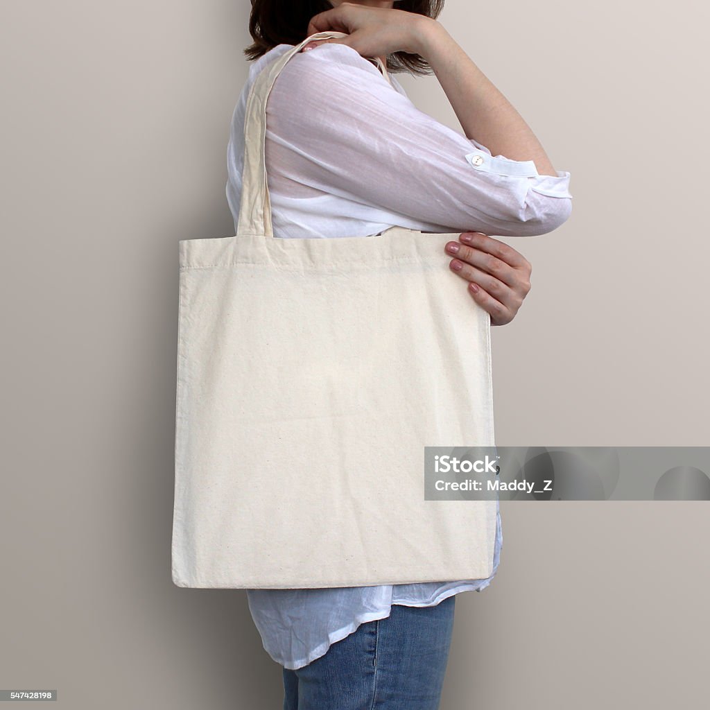 Girl is holding blank cotton eco bag, design mockup. Girl is holding blank cotton eco bag, design mockup. Handmade shopping bag for girls. Bag Stock Photo