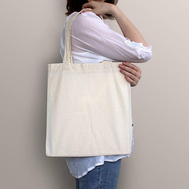 Girl is holding blank cotton eco bag, design mockup. Girl is holding blank cotton eco bag, design mockup. Handmade shopping bag for girls. tote bag mock up stock pictures, royalty-free photos & images
